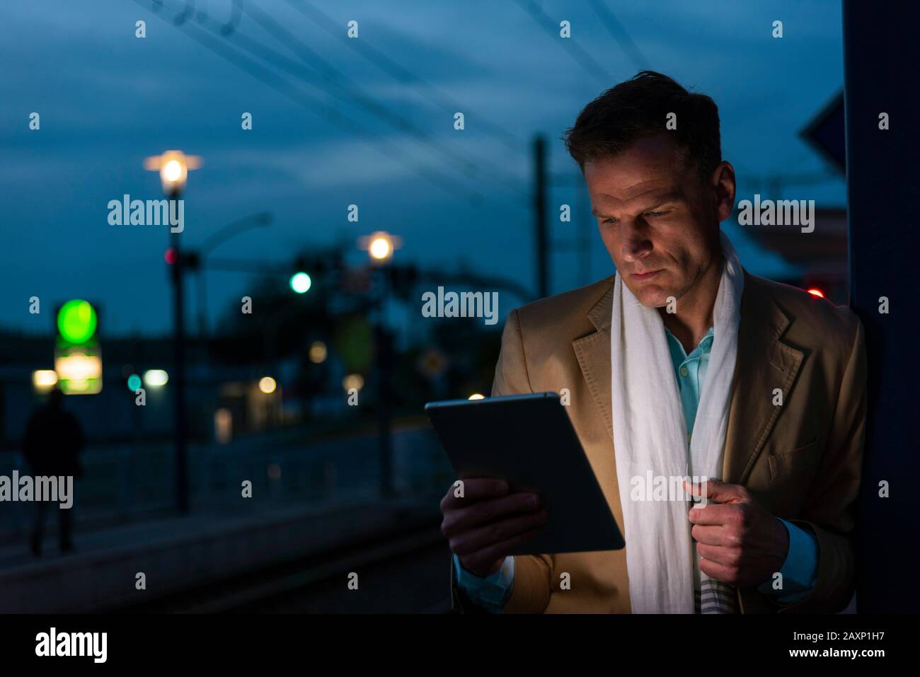 Homme d'affaires avec tablette dans la soirée à l'extérieur, demi-portrait Banque D'Images