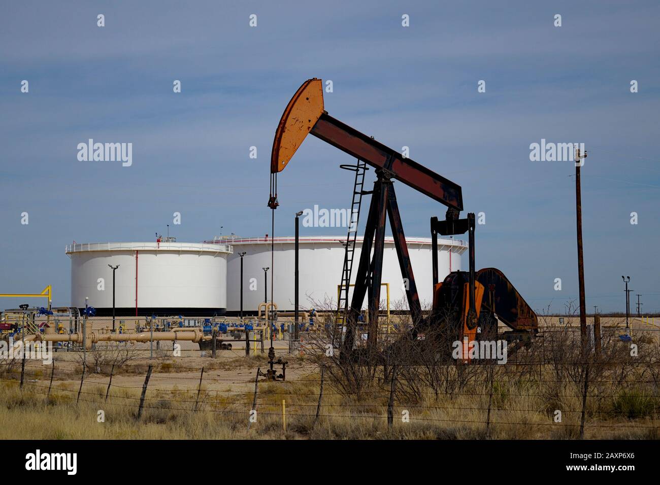 Unité de pompage et batteries de réservoir dans le bassin Permian. Une unité de pompage est visible au premier plan. Banque D'Images