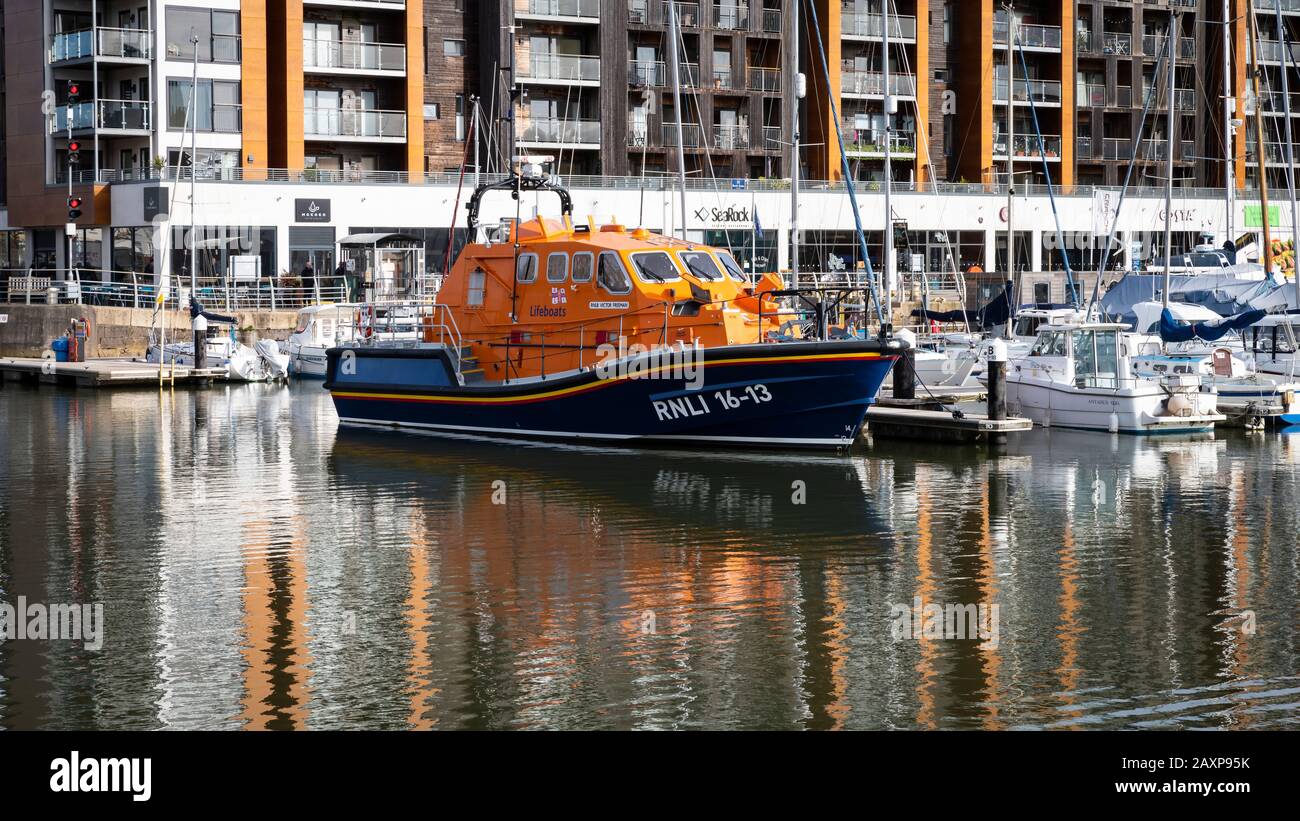 Port de plaisance de Portishead Quay, Angleterre Royaume-Uni : l'ancien bateau de sauvetage « Victor Freeman » a amarré dans la marina avec une toile de fond de magasins et d'appartements; réflexions sur l'eau. Banque D'Images