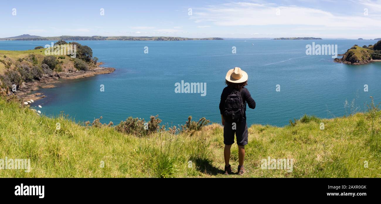 Touriste portant un short, un chapeau et une chemise noire, vue sur l'océan Banque D'Images