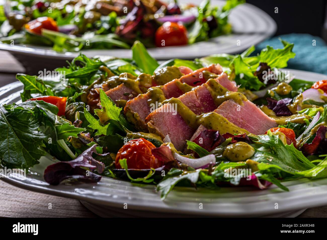 Bifteck de thon grillé en tranches sur les salades vertes. Banque D'Images