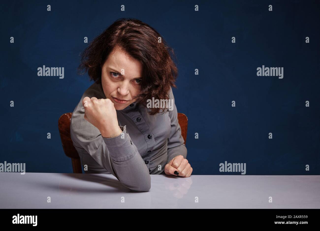 portrait d'une femme d'une humeur agressive, sur fond bleu foncé Banque D'Images
