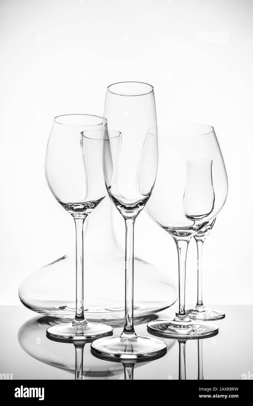 Sélection de verrerie avec vin, champagne, verres à liqueur et décanteur sur fond clair. Concept de verrerie fine crisstal. Vertical Banque D'Images
