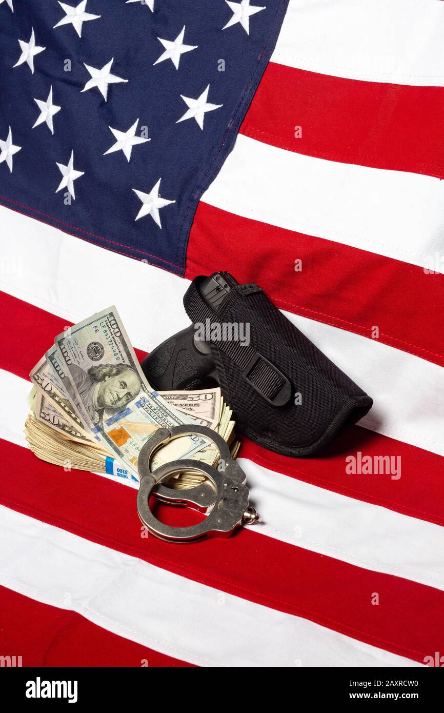 Pistolet, étui, menottes et argent devant le drapeau américain, vertical Banque D'Images