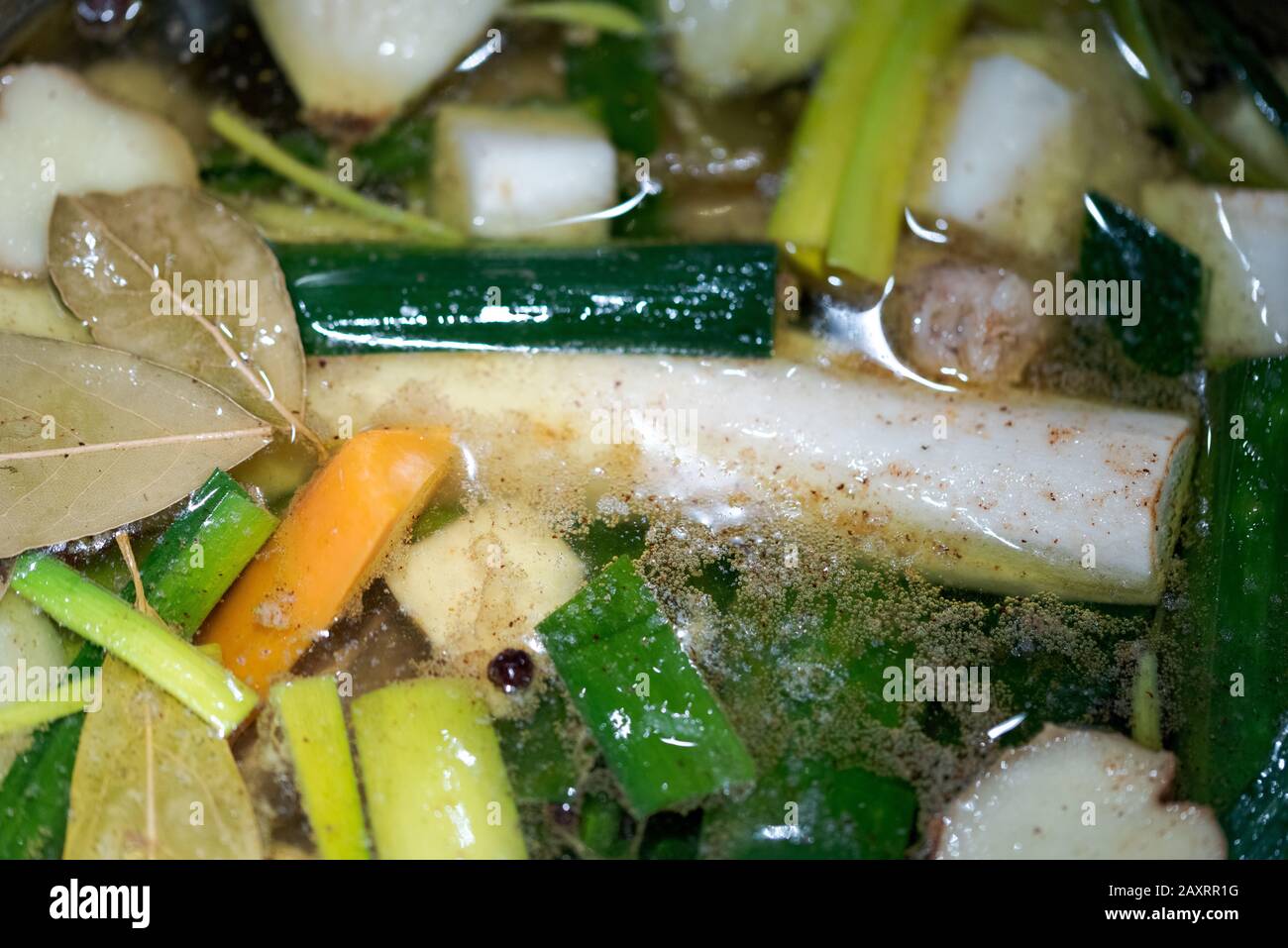 Gros plan du stock végétarien de légumes de racine qui se simmering dans une grande casserole Banque D'Images