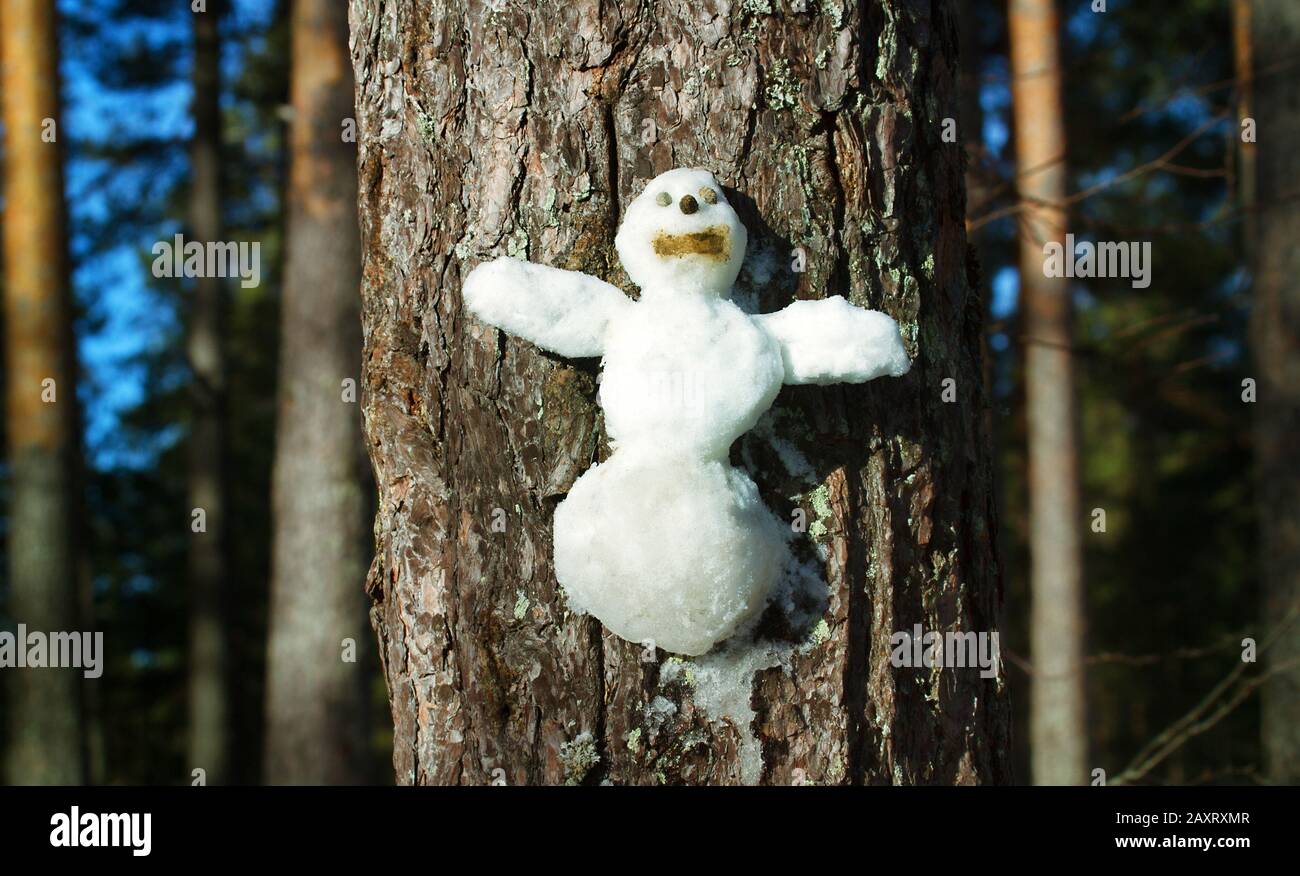 Le Snowman figurine sur un tronc d'arbre. Les personnages de conte de Noël l'hiver Banque D'Images