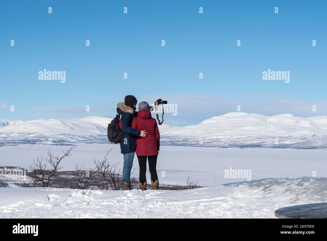 Suède, Laponie, point de vue, vue de la gelée Torneträsk, couple prenant des photos Banque D'Images