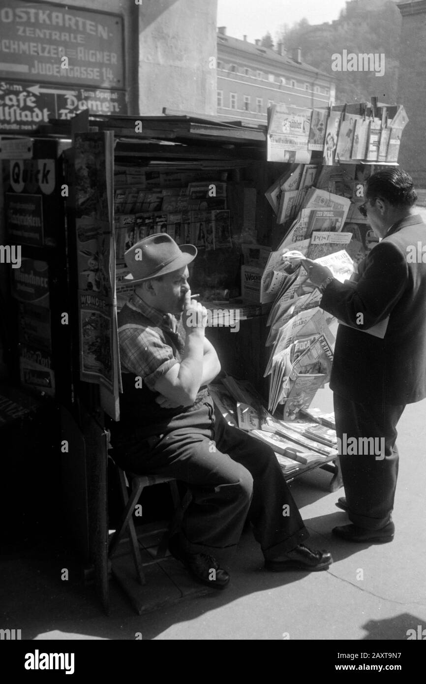 Zeitungsverkäufer und Kunde am Zeitungsstand am Residenzplatz, Salzbourg, 1957. Vendeur de journaux et client au kiosque du journal sur Residenzplatz, Salzbourg, 1957. Banque D'Images