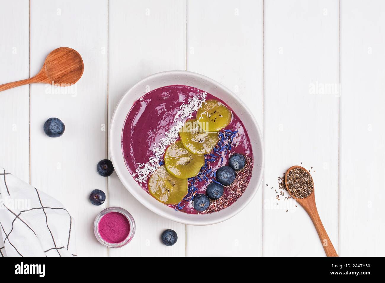 Bol à smoothie aux baies d'acai garni de graines, de fleurs et de mûres Banque D'Images