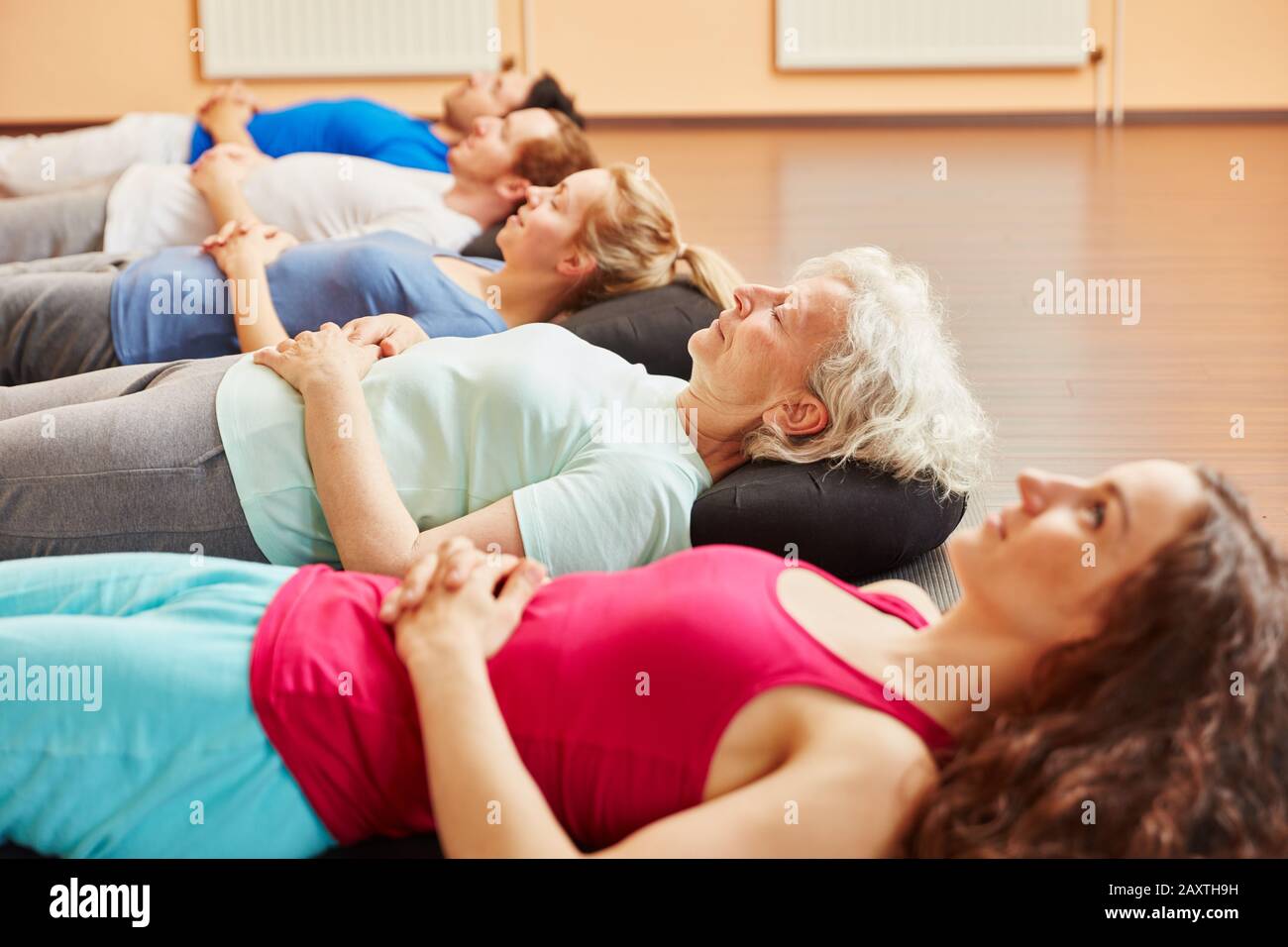 Le groupe fait de la méditation pour la relaxation après le cours de yoga Banque D'Images