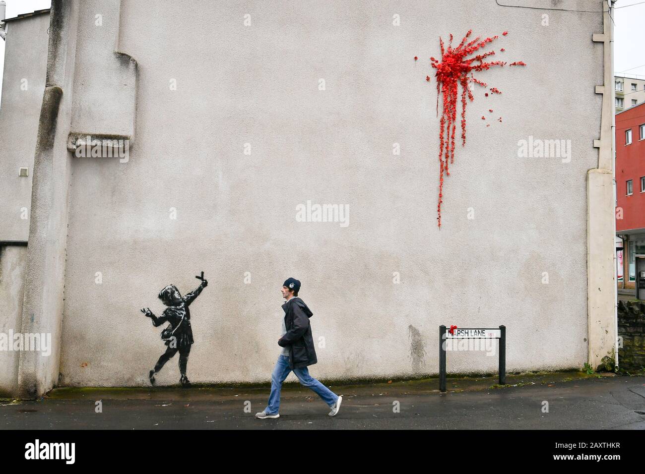 Une nouvelle œuvre d'art sur le côté d'une maison sur Marsh Lane, Barton Hill, Bristol, qui est considéré par l'artiste de rue Banksy. Le pochoir noir et blanc d'une fille avec un catapulte et la peinture splat, fait de roses et de fleurs en plastique, est dans le style de Banksy, mais doit encore être confirmé comme étant l'œuvre de l'artiste. Banque D'Images Une nouvelle œuvre d'art sur le côté d'une maison sur Marsh Lane, Barton Hill, Bristol, qui est considéré par l'artiste de rue Banksy. Le pochoir noir et blanc d'une fille avec un catapulte et la peinture splat, fait de roses et de fleurs en plastique, est dans le style de Banksy, mais doit encore être confirmé comme étant l'œuvre de l'artiste. Banque D'Images