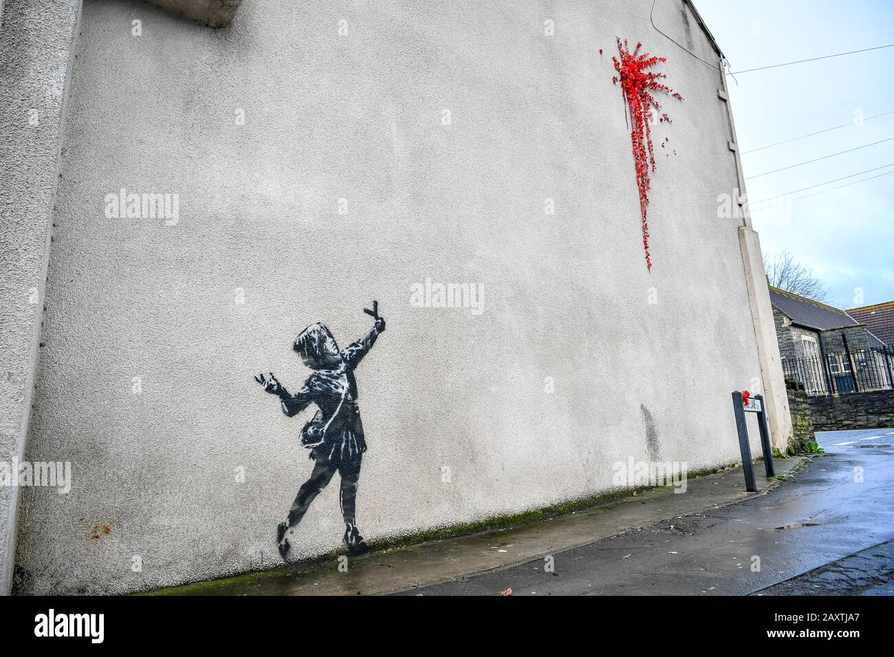 Une nouvelle œuvre d'art sur le côté d'une maison sur Marsh Lane, Barton Hill, Bristol, qui est considéré par l'artiste de rue Banksy. Le pochoir noir et blanc d'une fille avec un catapulte et la peinture splat, fait de roses et de fleurs en plastique, est dans le style de Banksy, mais doit encore être confirmé comme étant l'œuvre de l'artiste. Photo PA. Date De L'Image: Jeudi 13 Février 2020. Crédit photo devrait lire: Ben Birchall/PA Wire Banque D'Images