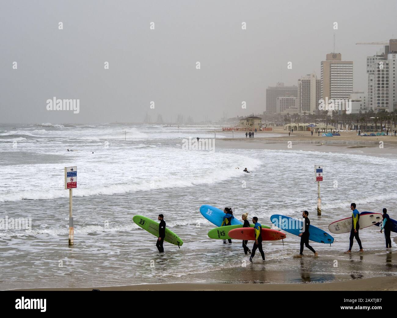 Tel Aviv, Israël - 12/15/2019: Les surfeurs s'entrainement avec leur planche sur les vagues de la mer Banque D'Images