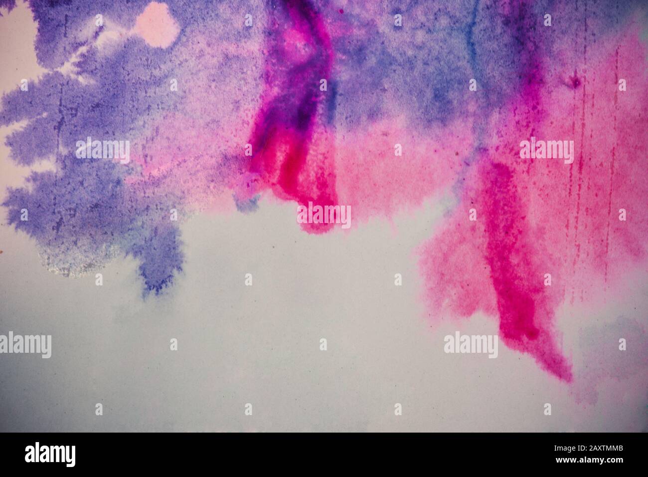 le point d'encre se répand sur du papier de couleur pourpre et rose Banque D'Images