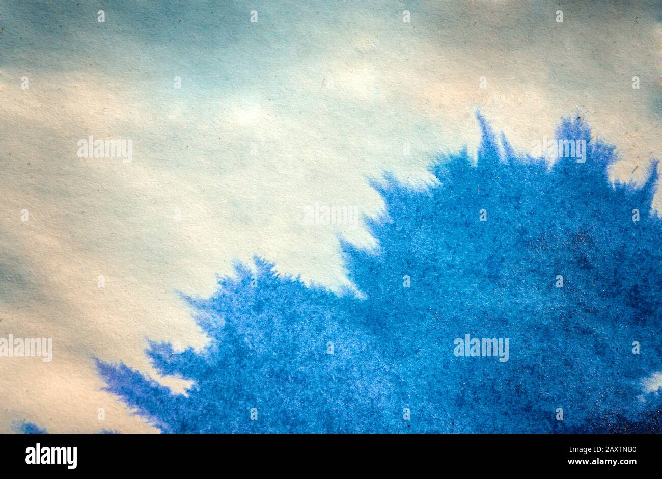 le point d'encre se répand sur le papier de couleur bleue Banque D'Images