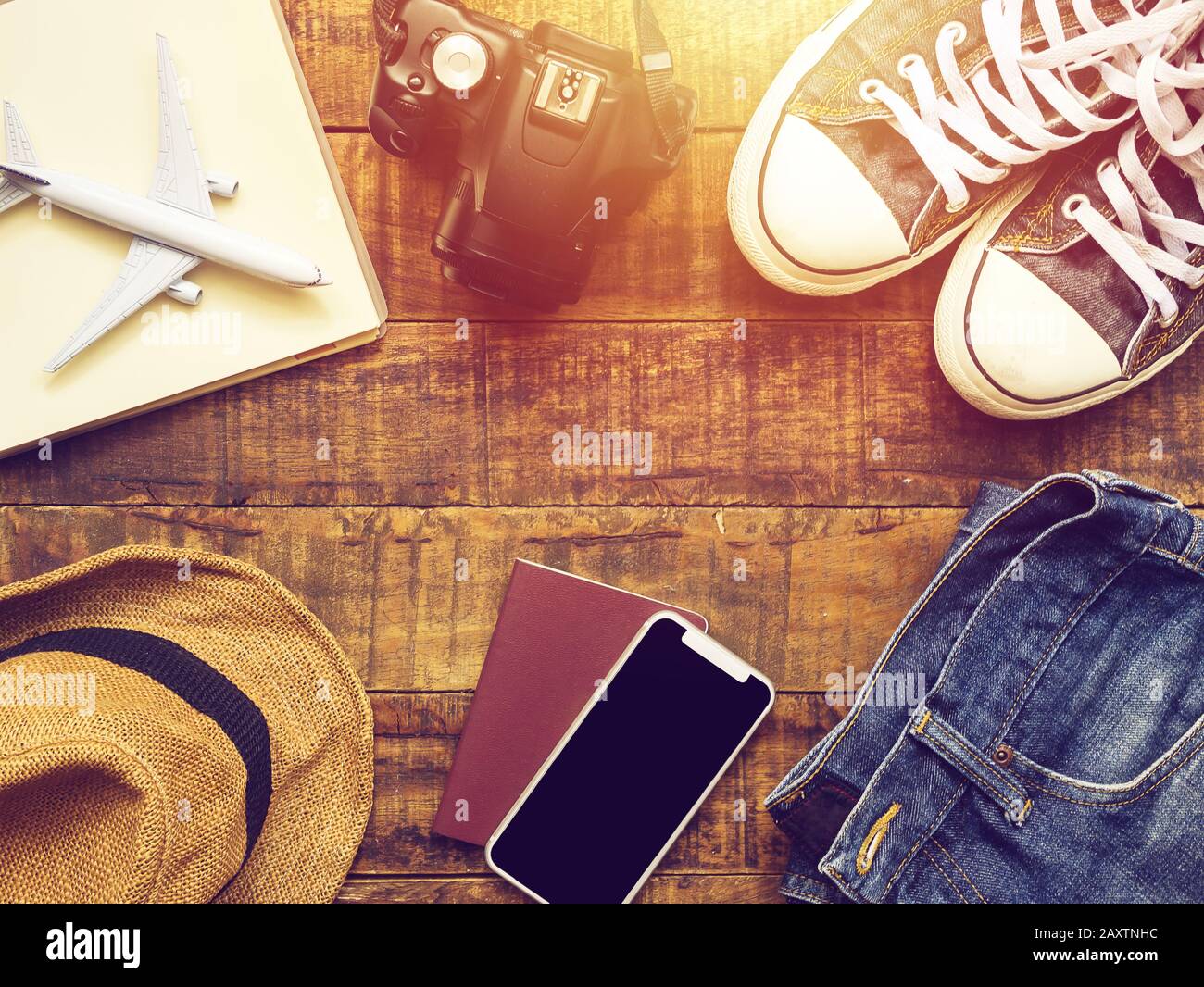 couche plate de passeport , mobile , modèle d'avion , baskets , appareil photo et accessoires de voyageur sur fond en bois avec espace de copie. voyage et vacances Banque D'Images