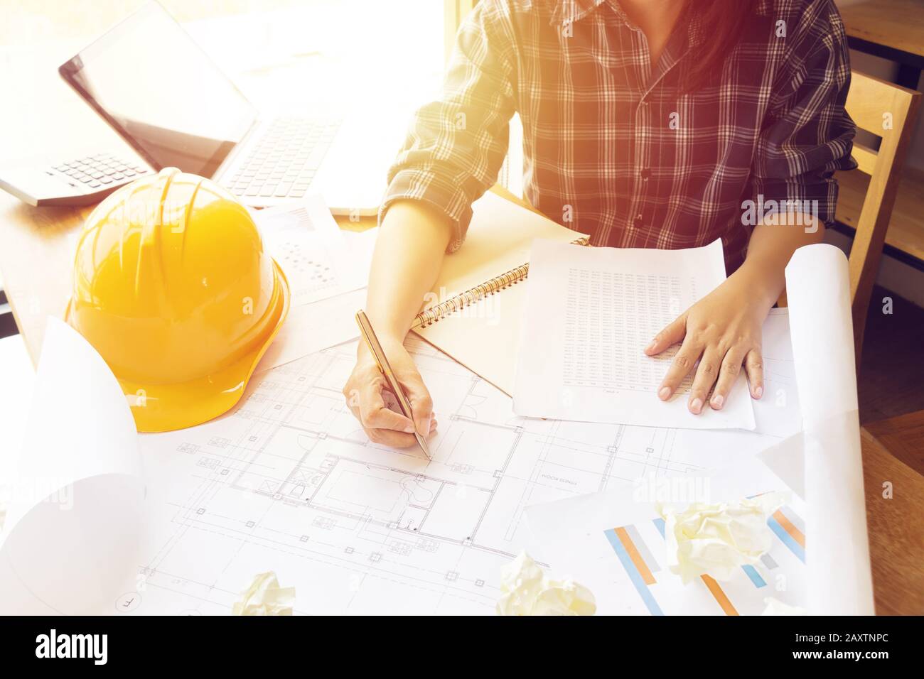 Architecte Asian femme travaillant avec ordinateur portable, calculatrice et plans. Ingénieur calcule et inspection sur le lieu de travail pour plans architecturaux plans Banque D'Images