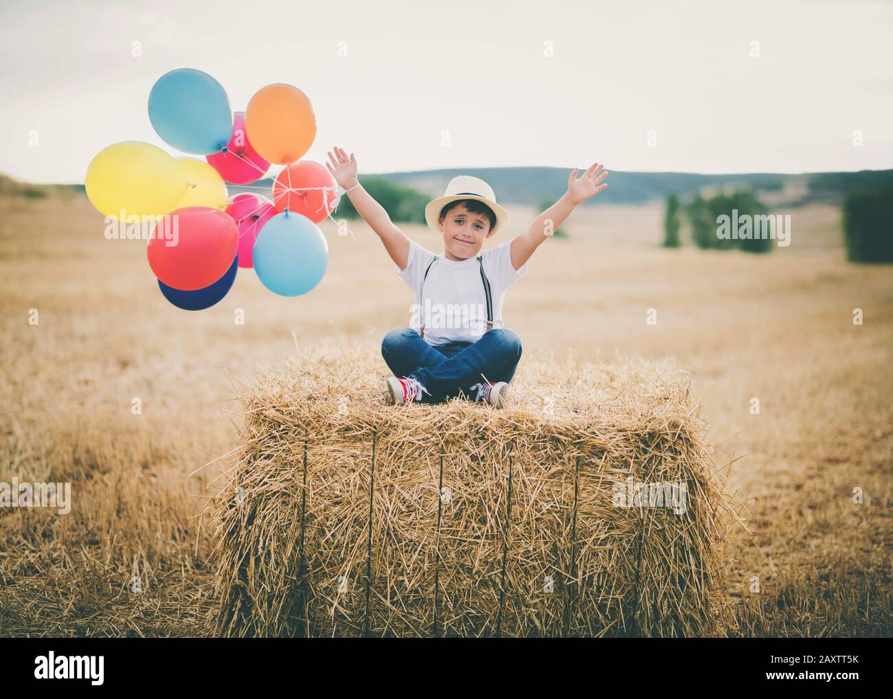 enfant heureux avec des ballons dans le champ de blé extérieur Banque D'Images