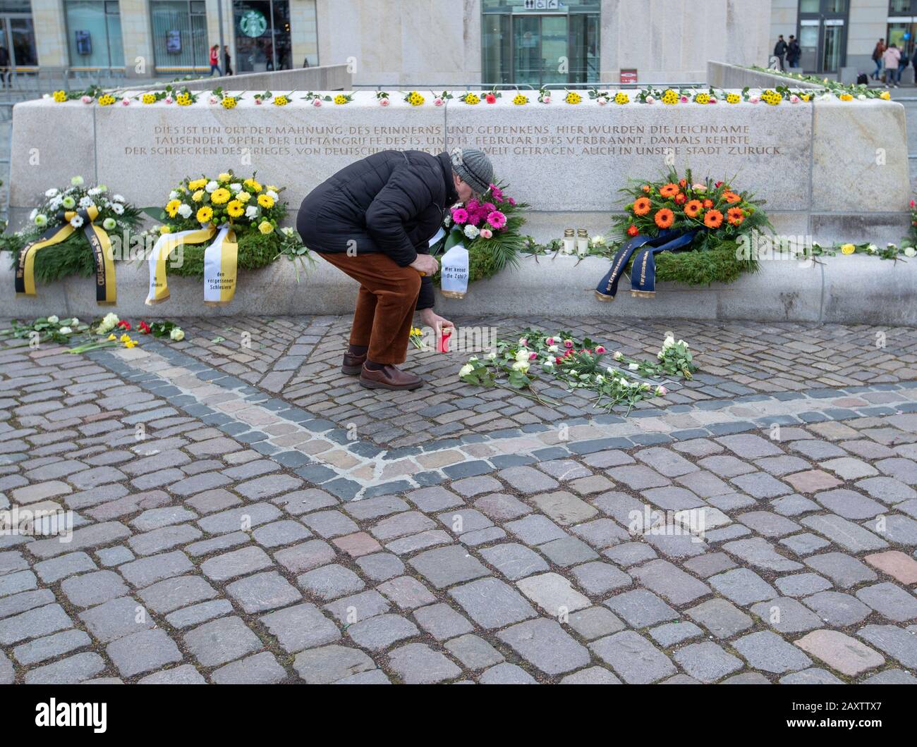 Dresde, Allemagne. 13 février 2020. Un homme met une lumière grave sur l'Altmarkt à un mémorial pour les victimes de l'attentat à la bombe de Dresde il y a 75 ans dans la seconde Guerre mondiale. À l'occasion du 75ème anniversaire de la destruction de Dresde au cours de la seconde Guerre mondiale, la ville commémore de nombreux événements. Les 13 et 14 février 1945, les bombardiers alliés ont réduit le centre de la ville d'Elbe en ruines et en cendres. Jusqu'à 25 000 personnes ont perdu la vie. Crédit: DPA Picture Alliance/Alay Live News Banque D'Images
