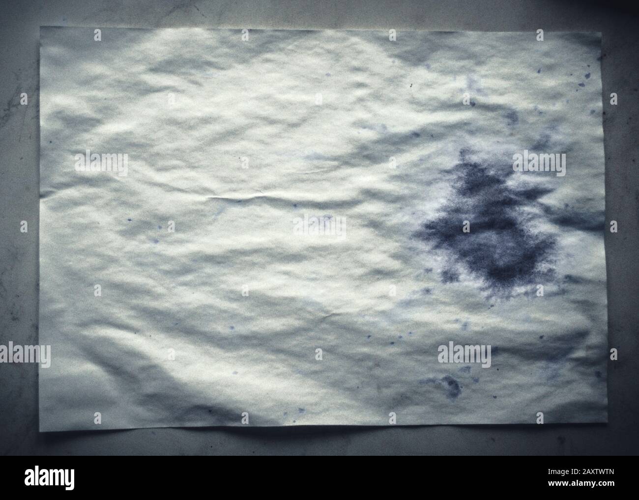 L'encre grise s'est enroulée sur une feuille de papier froissée sur la table, fond de base abstrait. Espace pour le texte Banque D'Images