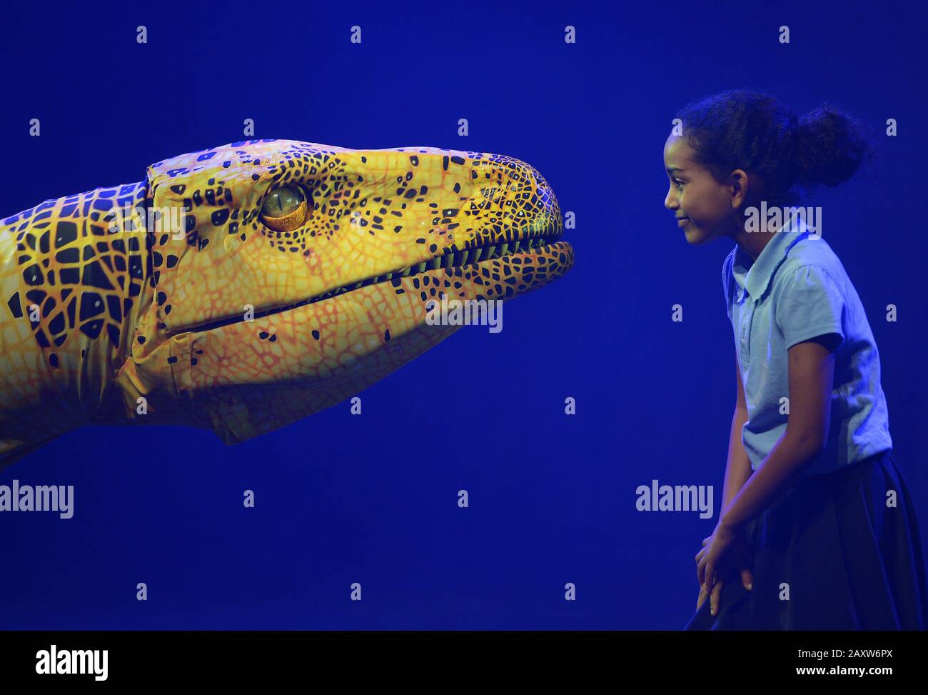 Élève de la Stockwell Primary School de Londres, interagit avec une marionnette de dinosaures Fukuiraptor du zoo des dinosaures d'Erth dans le Queen Elizabeth Hall, au Southbank Center de Londres, avant une représentation dans le cadre du Imagine Children's Festival. Banque D'Images