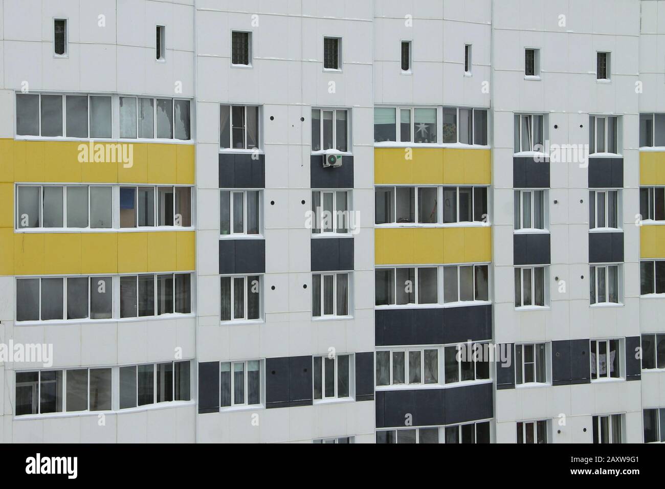 Bâtiment moderne en briques de plusieurs étages, carrelage blanc, décoré de panneaux gris foncé et jaunes. Le concept d'acquisition de nouveaux logements et le niveau de logement, l'architecture urbaine moderne Banque D'Images