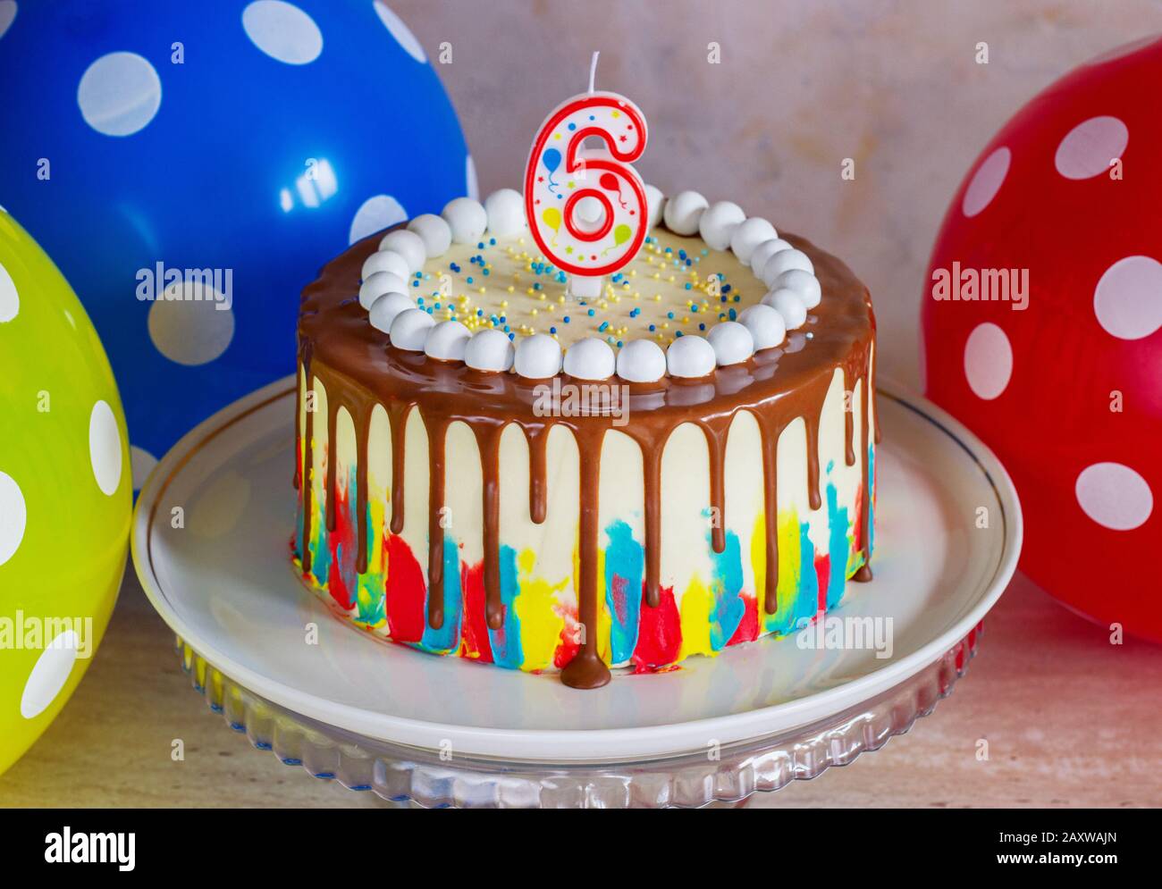 gâteau d'anniversaire brillant avec chocolat sur un fond clair avec des ballons Banque D'Images