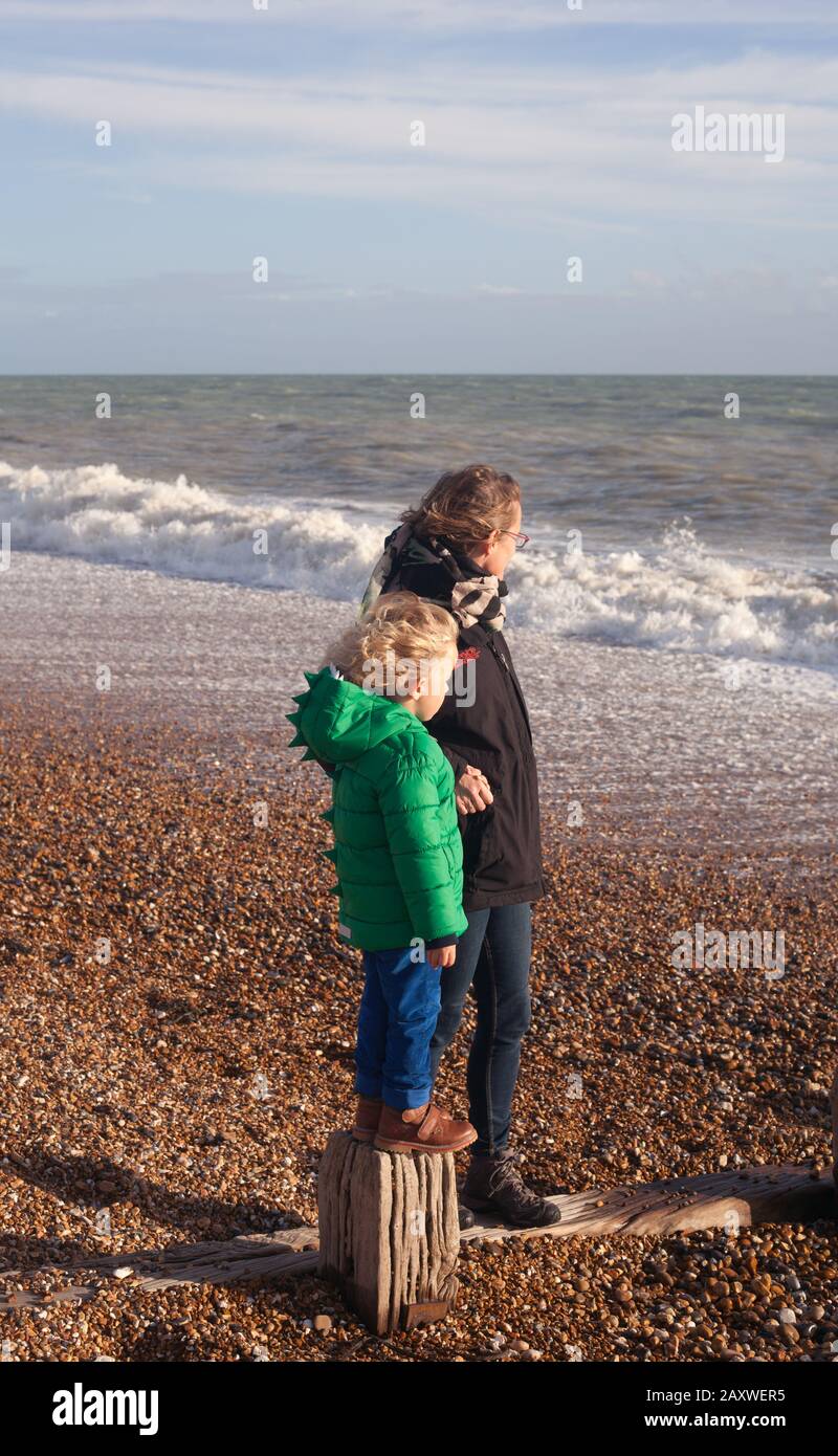 Mère et fils sur la plage profitant de l'air marin et du soleil d'hiver, Bulverthythe, Hastings, East Sussex, Royaume-Uni Banque D'Images