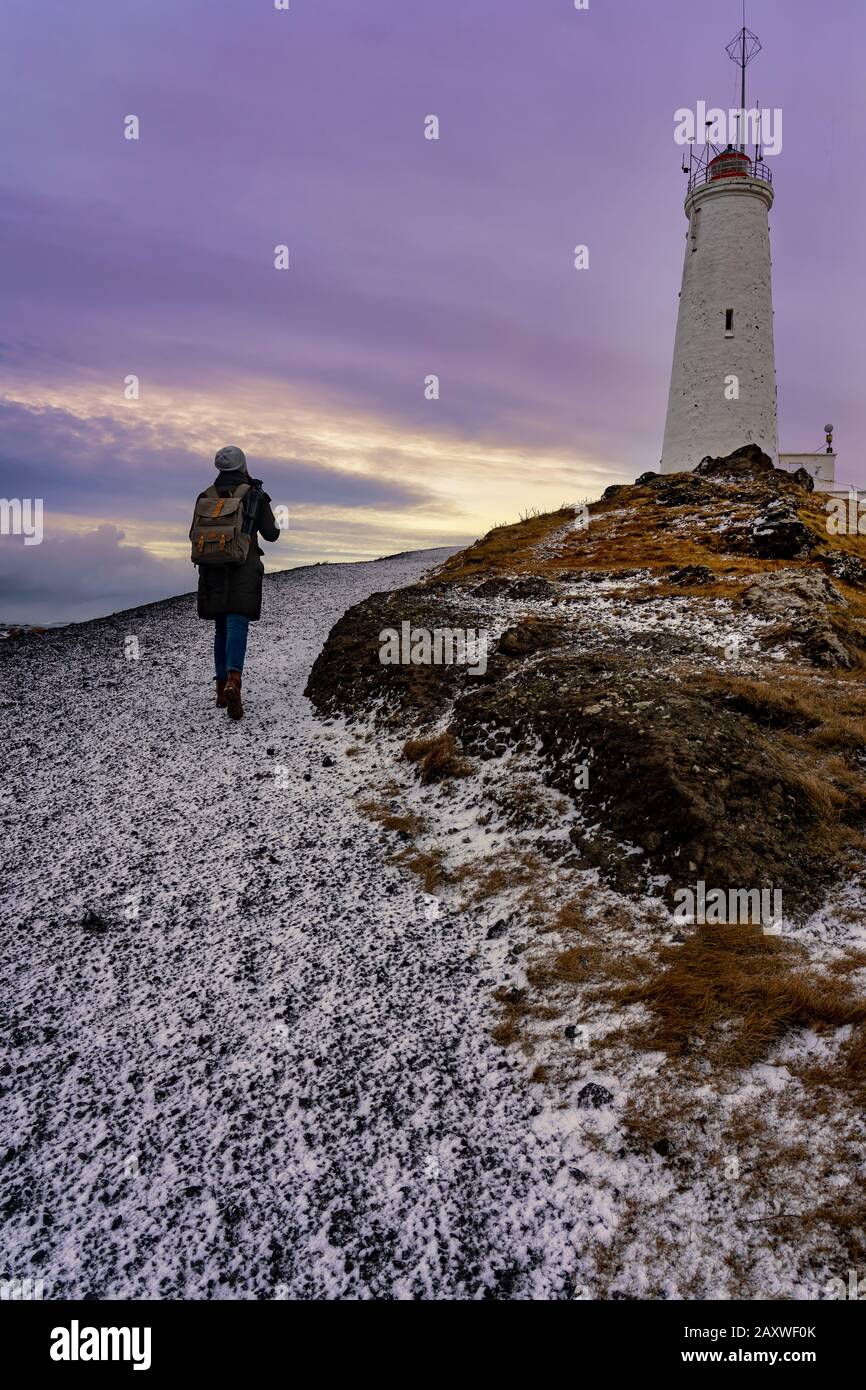 Femme de tourisme avec sac à dos photographe faisant au phare de la péninsule de Reykjavik Reykjanes Reykjanesviti Banque D'Images