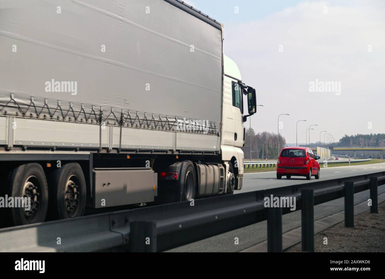 Autoroute. Deux usagers de la route : un grand camion et une petite voiture de tourisme. Banque D'Images