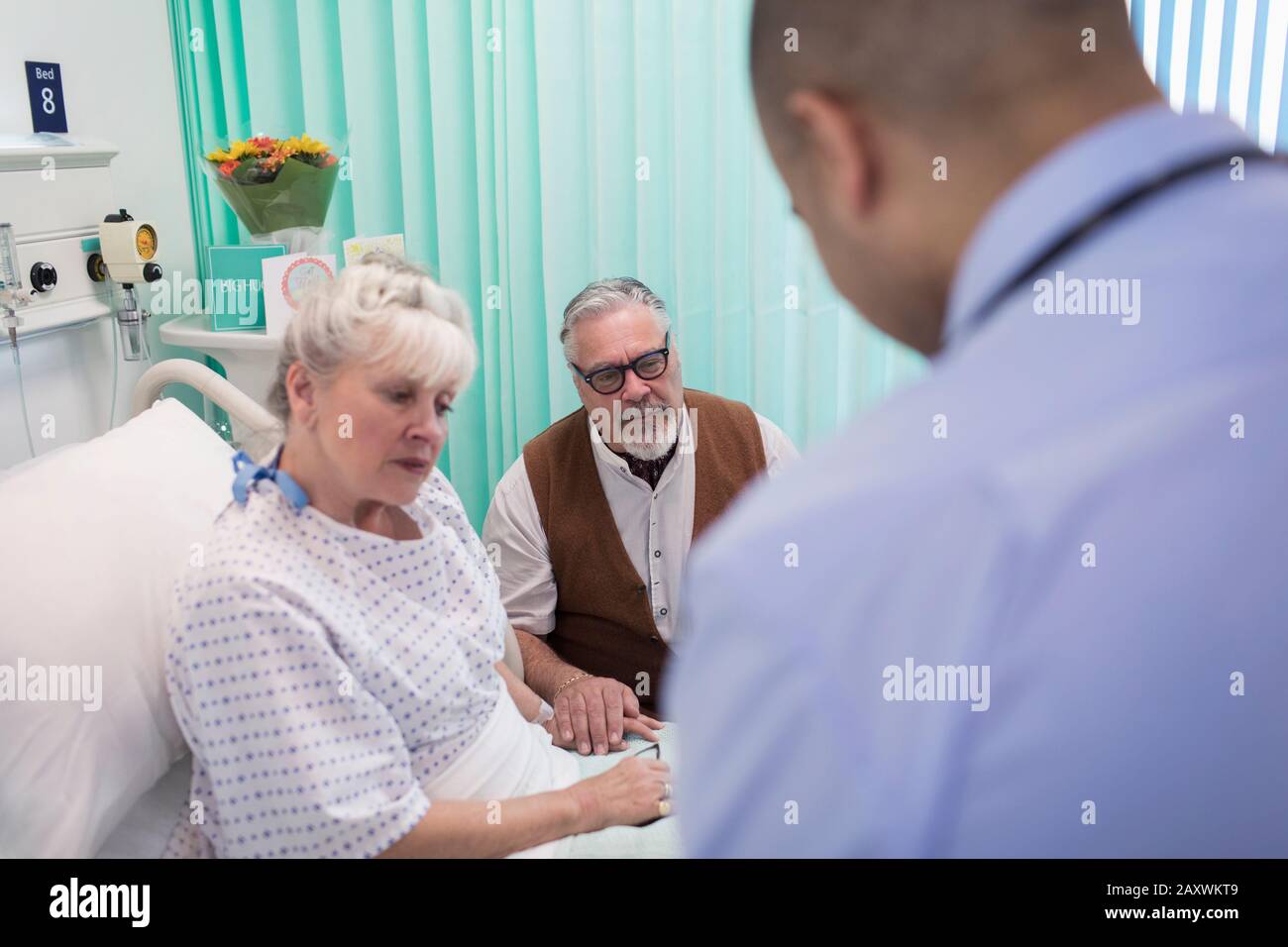 Médecin effectuant des rondes, en parlant avec un couple senior dans la chambre d'hôpital Banque D'Images