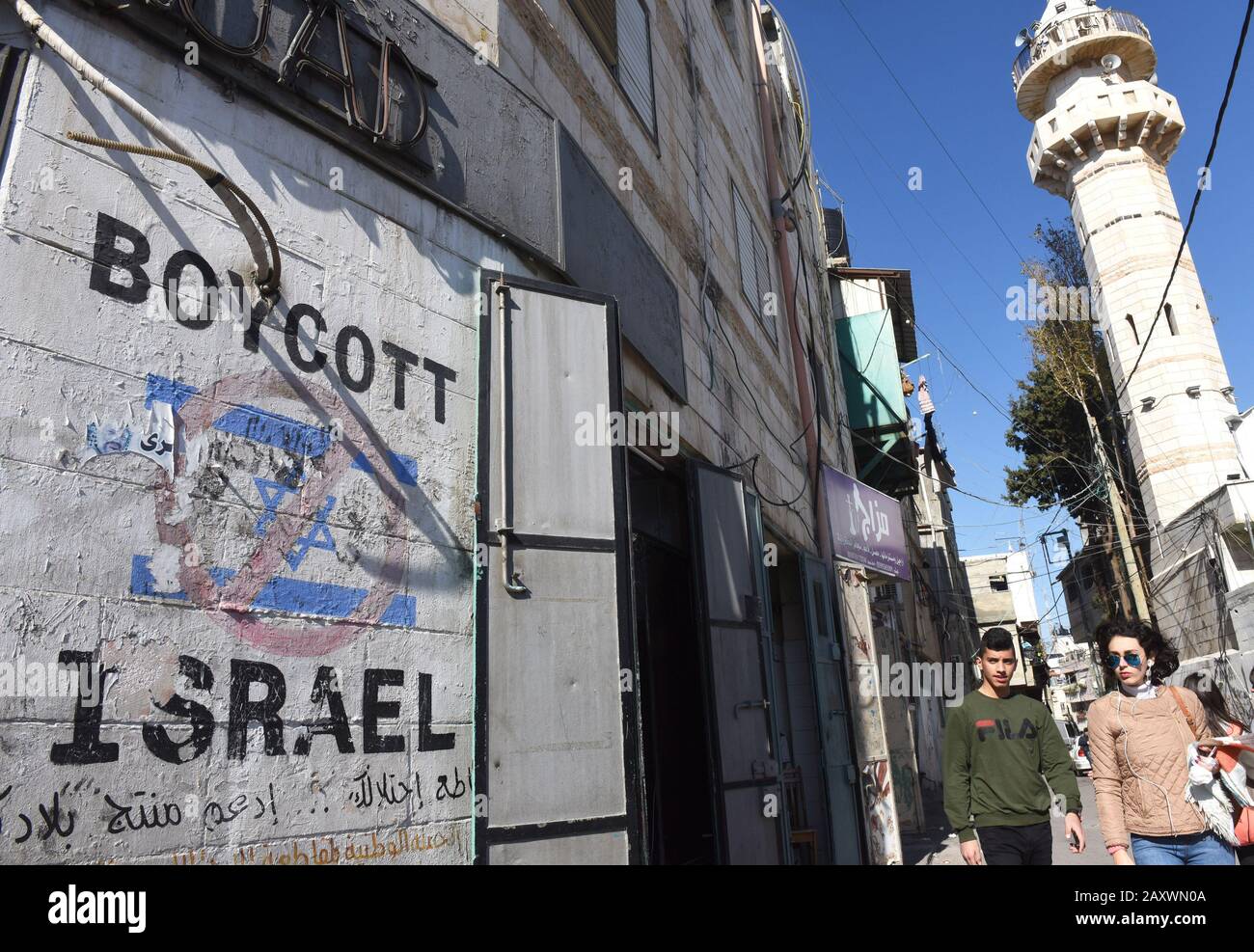 Bethléem, Gaza. 13 février 2020. Les Palestiniens passent des graffitis appelant à un boycott d'Israël à Bethléem, en Cisjordanie, le jeudi 13 février 2020. Le Premier ministre israélien Benjamin Netanyahu a fait un retour après que le Conseil des droits de l'homme des Nations Unies ait publié hier une liste d'entreprises opérant dans les colonies de Cisjordanie. Photo par Debbie Hill/UPI crédit: UPI/Alay Live News Banque D'Images