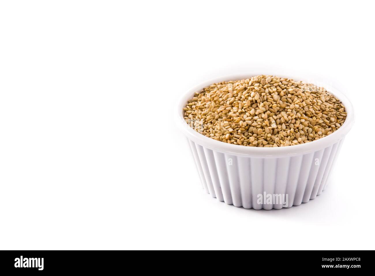Graines de lin doré dans un bol blanc isolées sur fond blanc. Espace de copie Banque D'Images