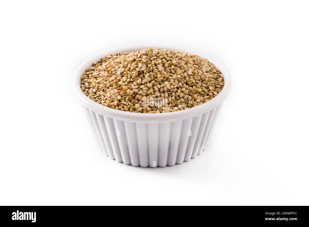 Graines de lin doré dans un bol blanc isolées sur fond blanc Banque D'Images