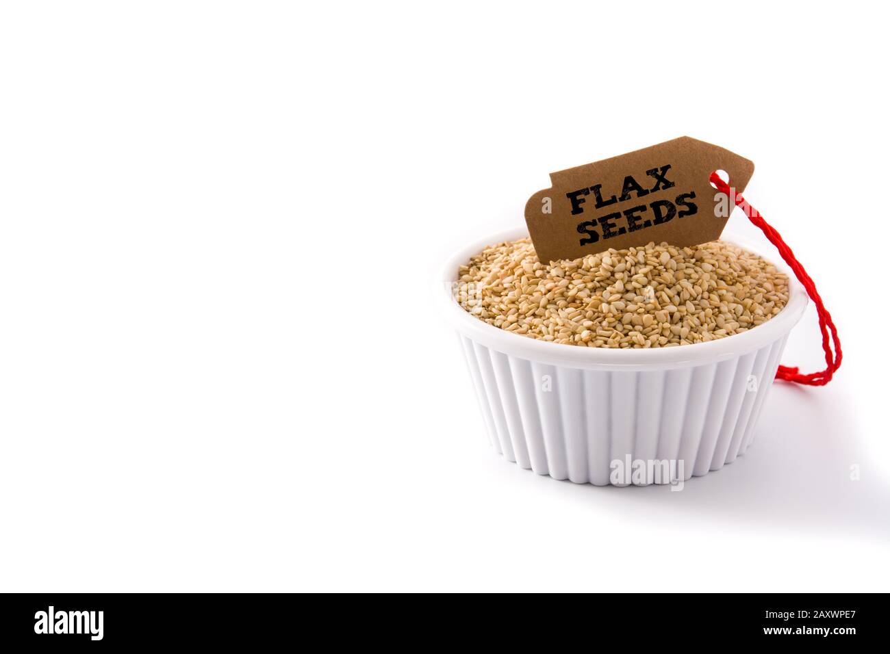 Graines de lin doré dans un bol blanc isolées sur fond blanc. Espace de copie Banque D'Images