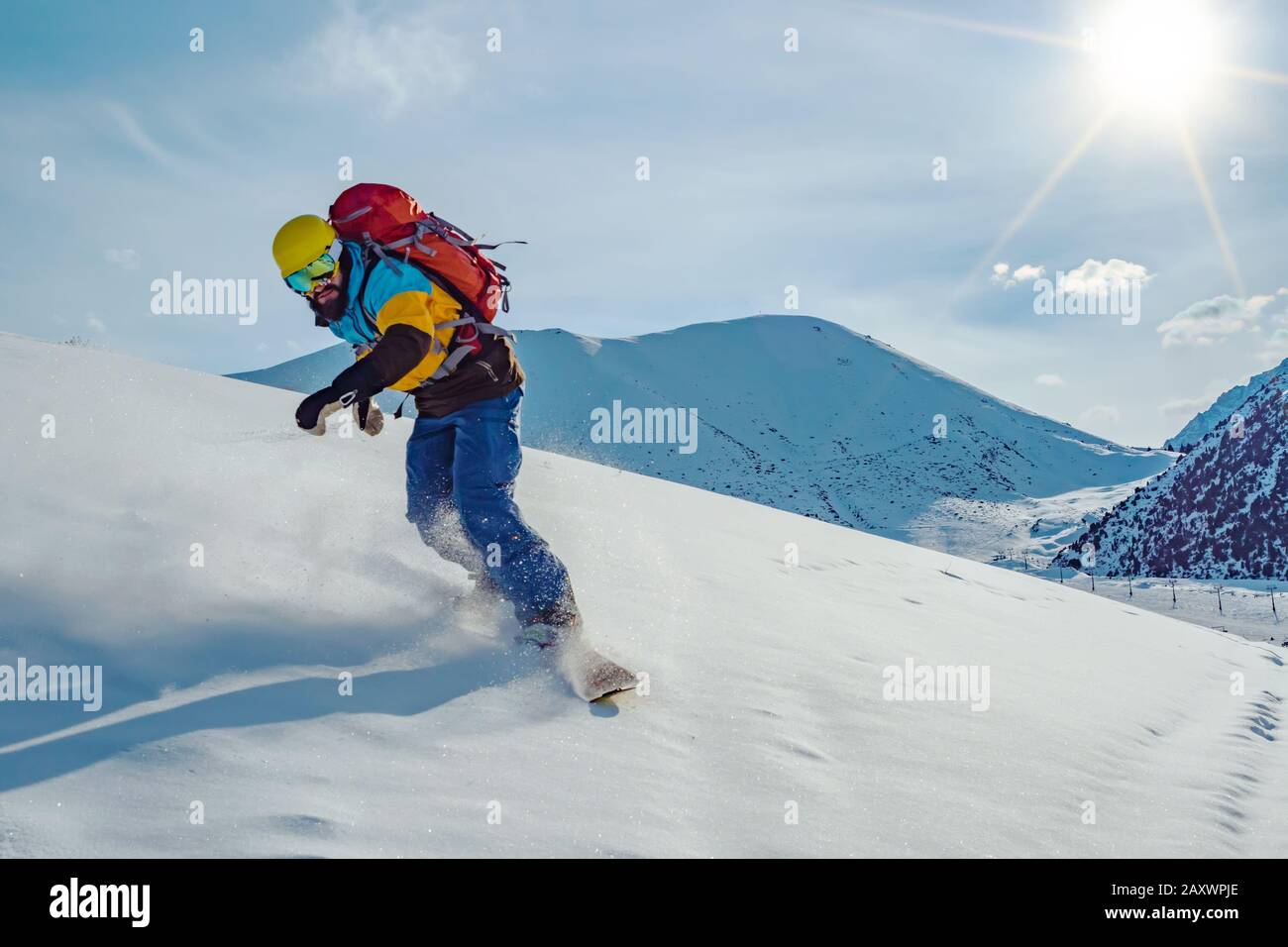 Un jeune homme est en snowboard. Neige intacte dans les montagnes. Montagnes du kirghizstan Banque D'Images