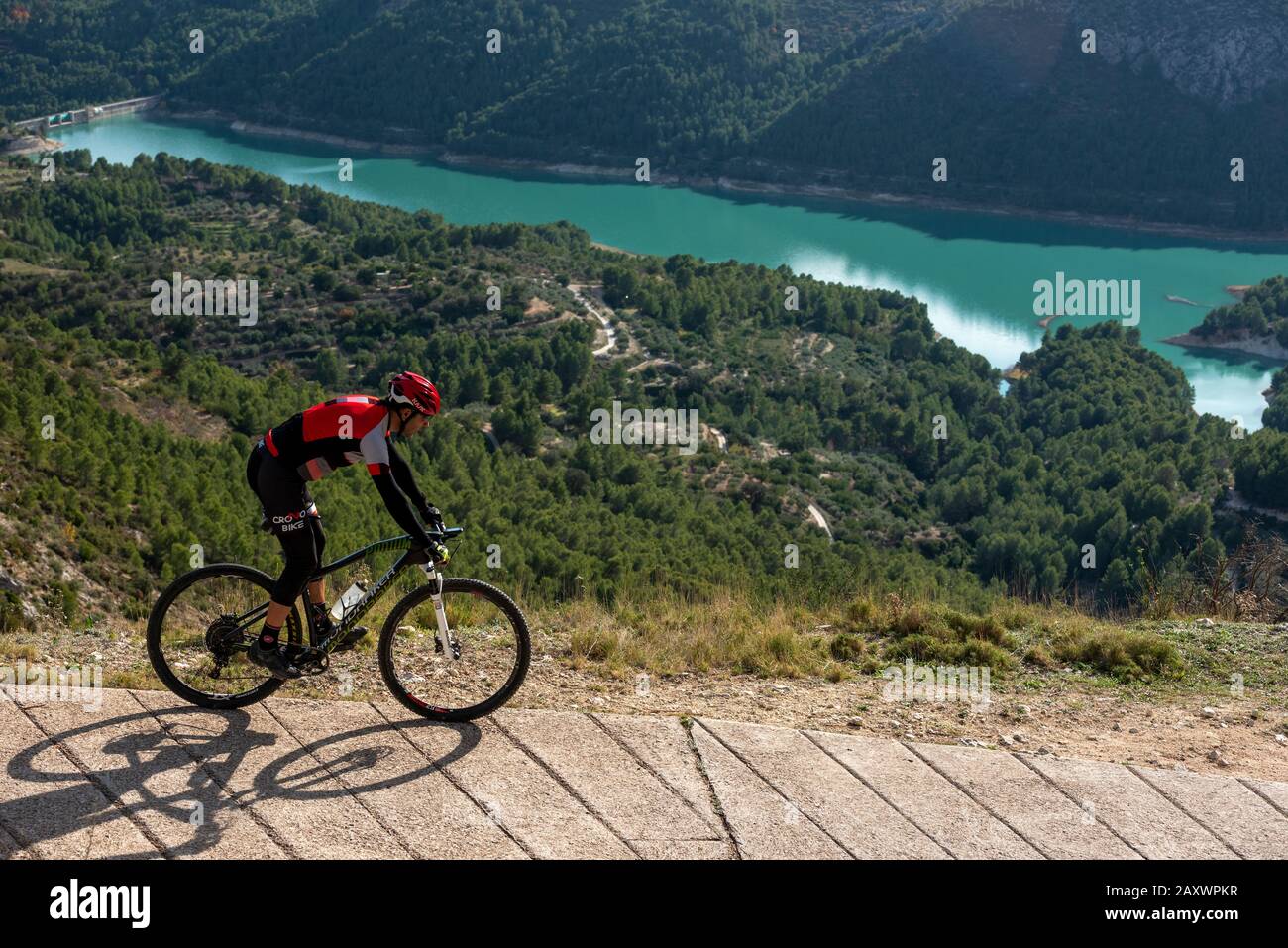 Homme avec VTT sur une route de campagne en béton, région de Guadalest, province d'Alicante, Costa Blanca, Espagne Banque D'Images