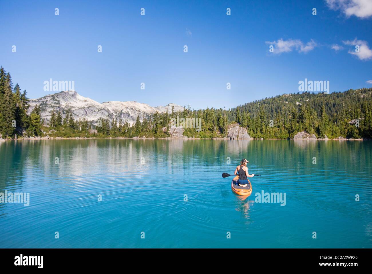 Femme active pagaies Stand up paddle board sur le lac bleu. Banque D'Images