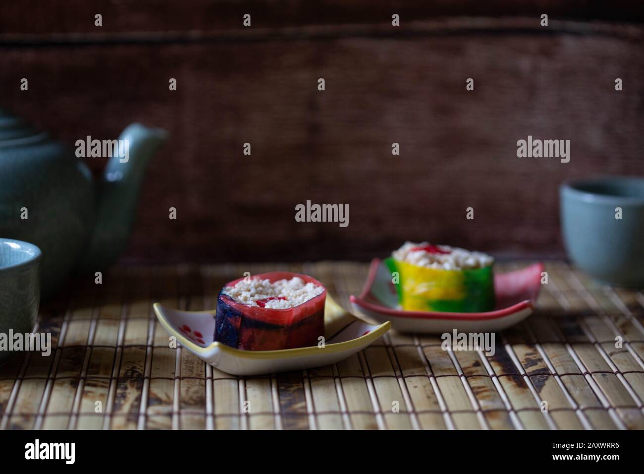 Gros plan sur les sushis de bonbons sur le tapis de bammboo avec le thé en arrière-plan. Banque D'Images