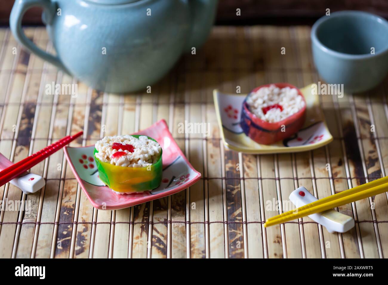 Des sushis et des baguettes de bonbons sont mis en place sur un tapis de bambou pour la cérémonie du thé. Banque D'Images