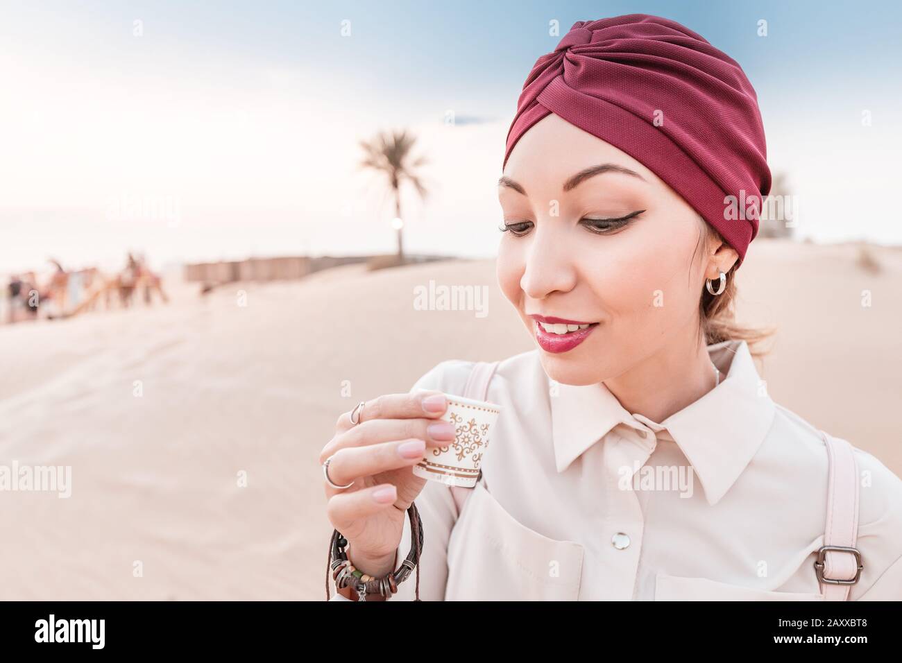 Femme musulmane avec dégustation de turban café arabe tout en ayant une visite et excursion dans le désert du milieu de l'est Banque D'Images