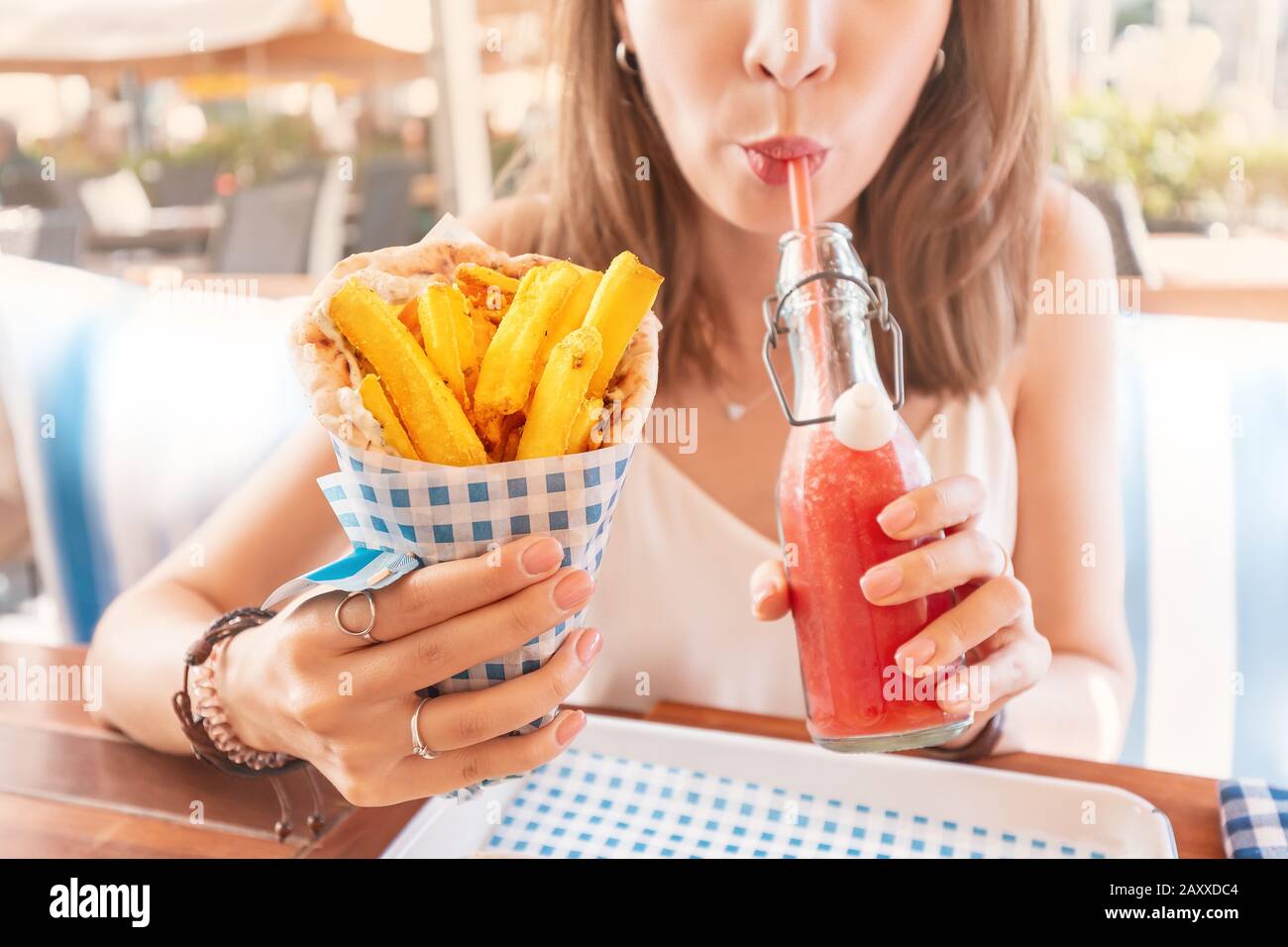 une jeune fille du café de la cuisine de rue mange des gyros savoureux et juteux avec pita. Concept de cuisine du Moyen-Orient Banque D'Images