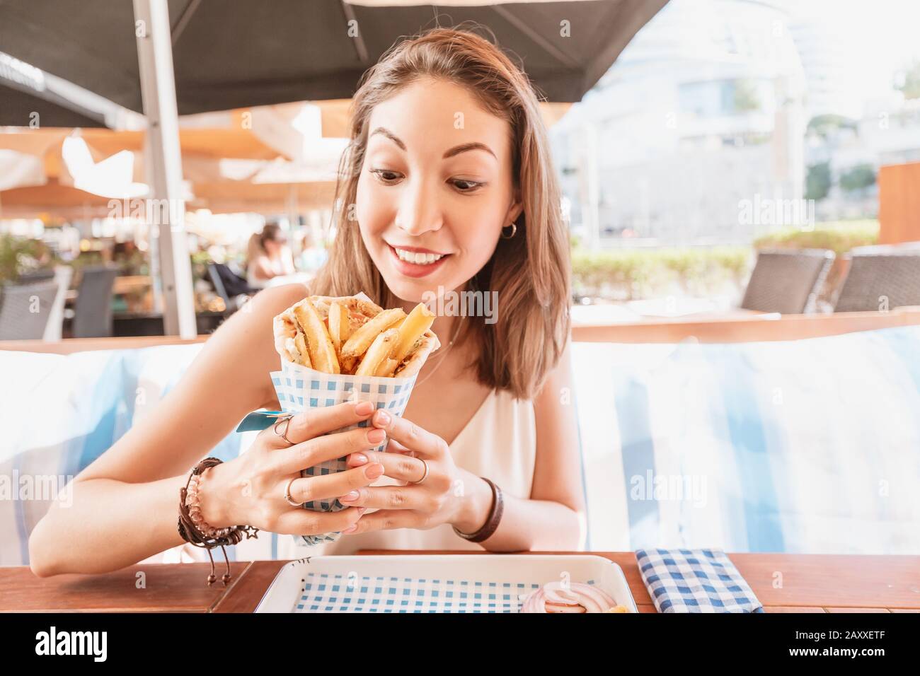 une jeune fille du café de la cuisine de rue mange des gyros savoureux et juteux avec pita. Concept de cuisine du Moyen-Orient Banque D'Images