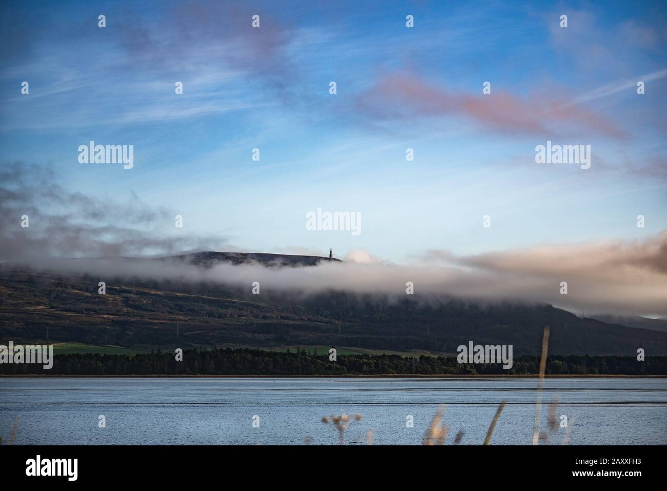 Nuages roses au lever du soleil sur le Loch Fleet, vue vers la statue du duc de Sutherland Banque D'Images