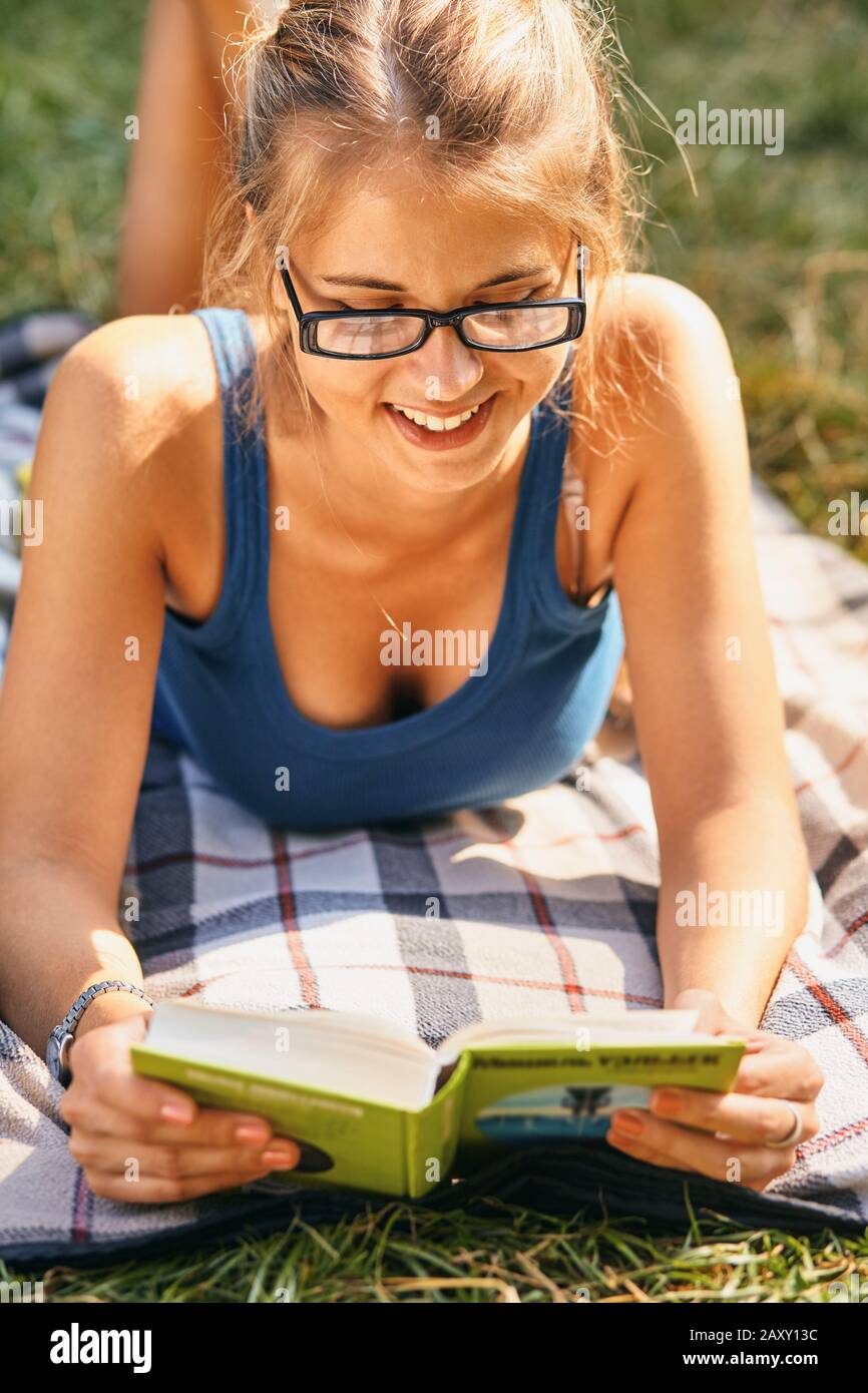 jeune, belle fille tenant un livre ouvert, lire l'arrière-plan été parc vert Banque D'Images