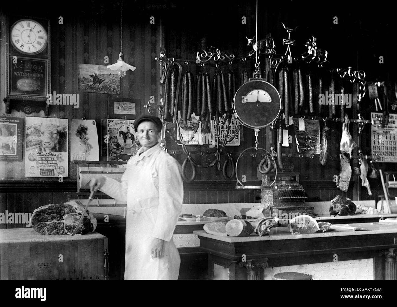 Un boucher pose fièrement dans son tour du siècle boucherie magasin, ca. 1900. Banque D'Images