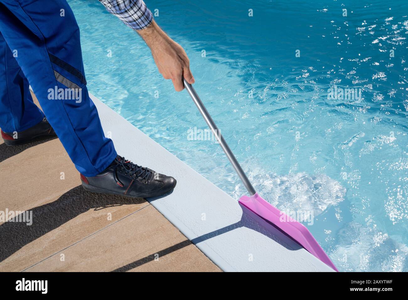 Travailleur Masculin Dans La Piscine De Nettoyage Uniforme Banque D'Images