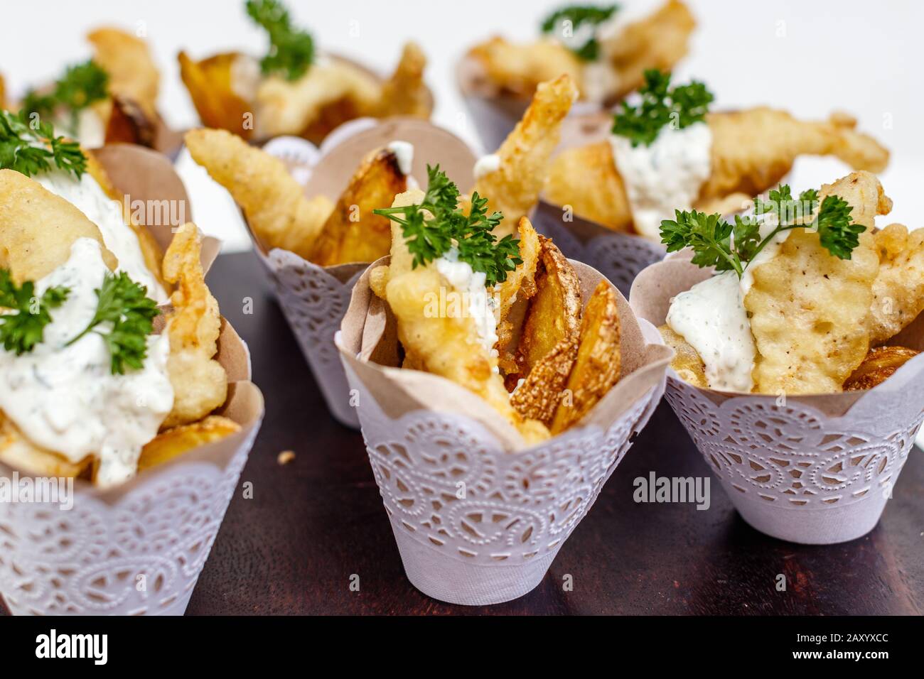 Poisson et chips servis dans des cônes en papier pour servir individuellement. Décoré de persil. Banque D'Images