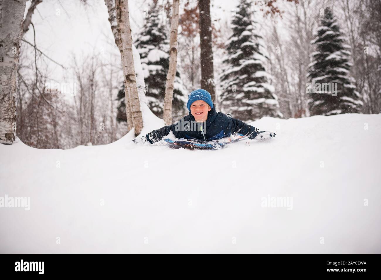 Un garçon souriant qui grésillement dans la neige, Wisconsin, États-Unis Banque D'Images