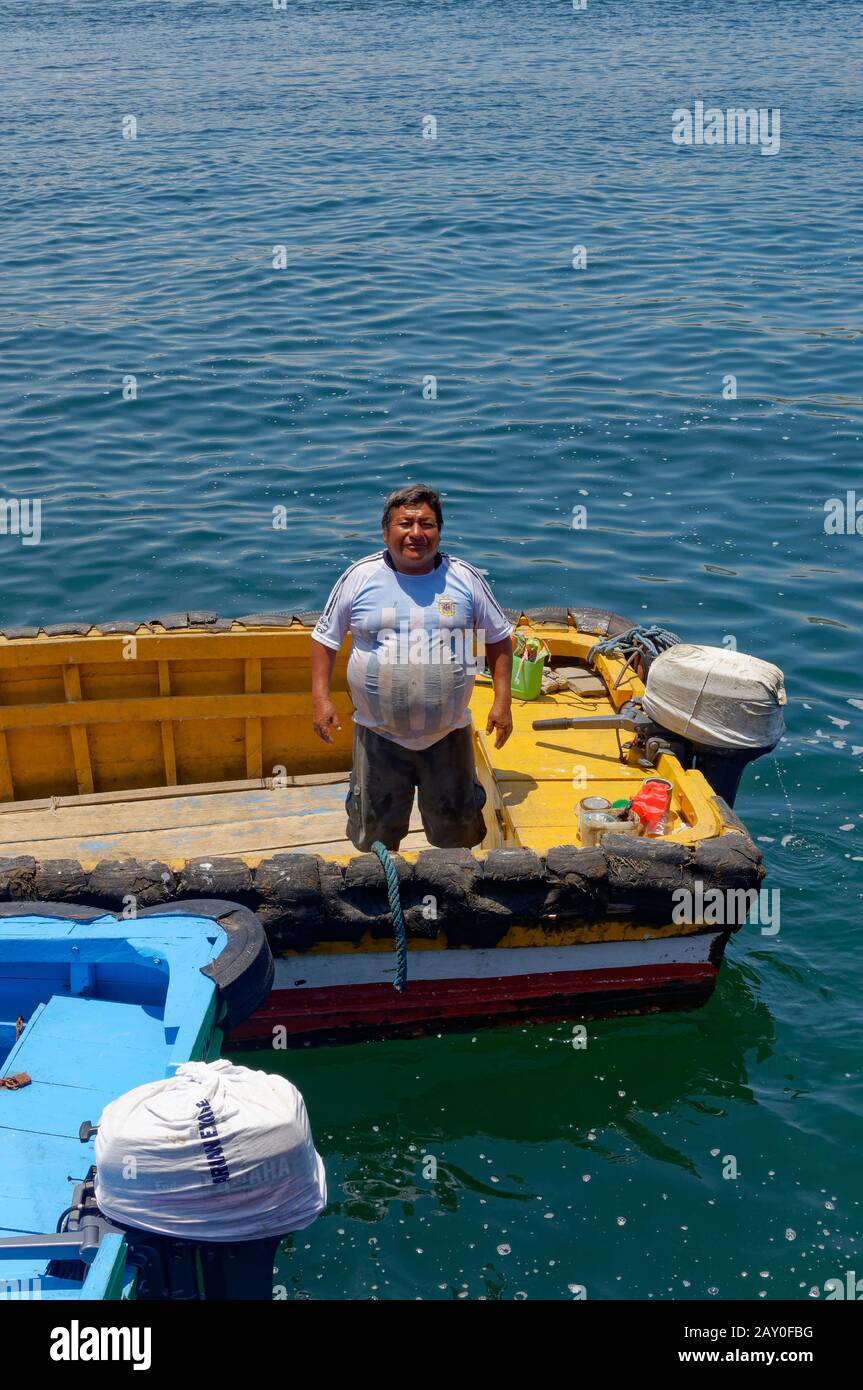 Un pêcheur local debout dans la poupe de son navire en attendant Les Passagers sur un changement d'équipage à prendre à terre à Chimera. Banque D'Images